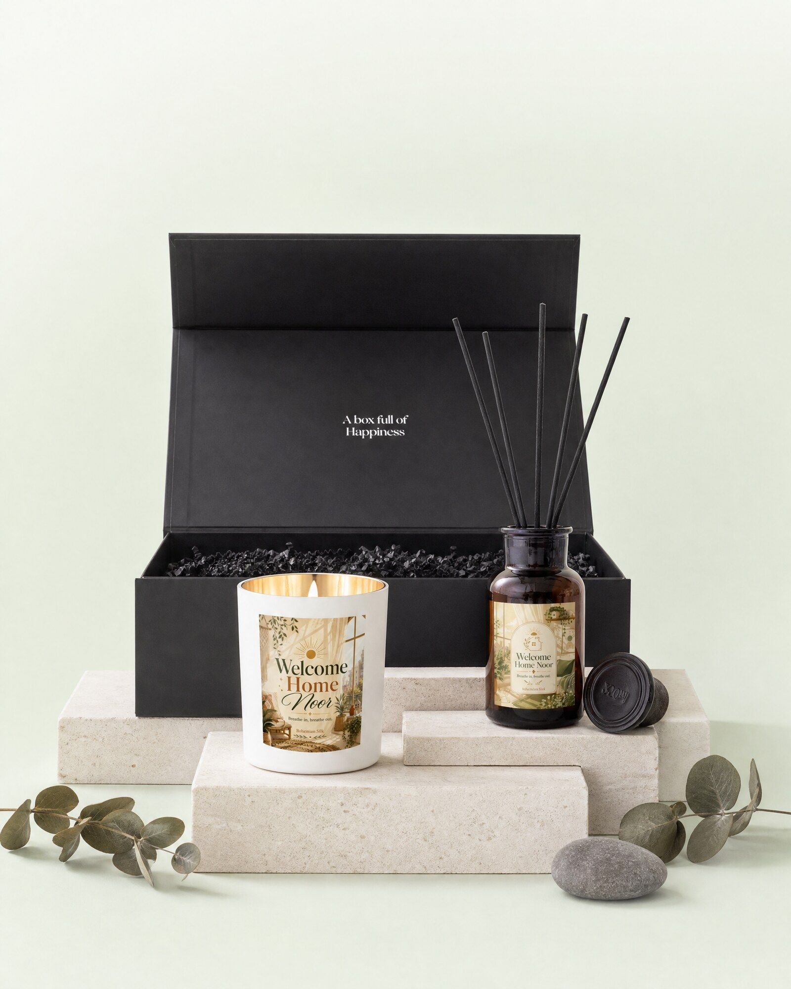 Cadeaubox met gepersonaliseerde geurkaars en geurstokjes, opgesteld voor de open zwarte geschenkdoos
