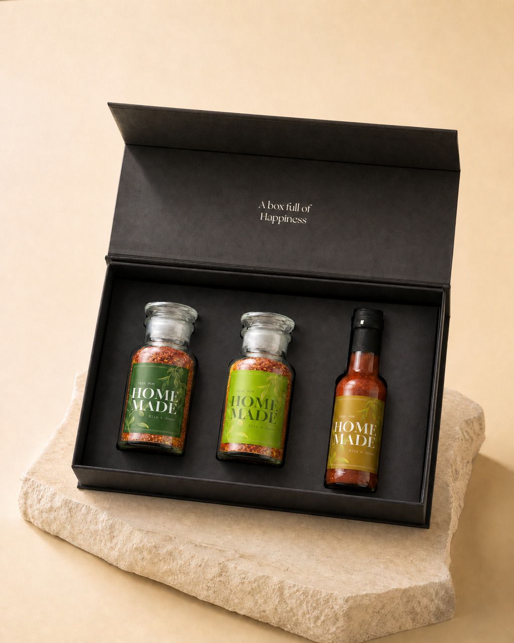 Gepersonaliseerde cadeaubox met kruiden en saus, de zwarte doos open met beide kruidenpotten en de sausfles erin