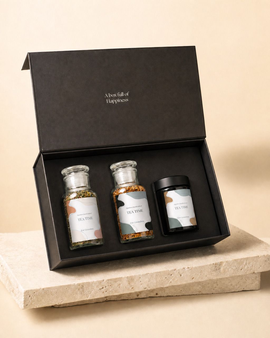 Gepersonaliseerde cadeaubox met thee en honing, de zwarte doos open met beide theepotten en de honingpot erin