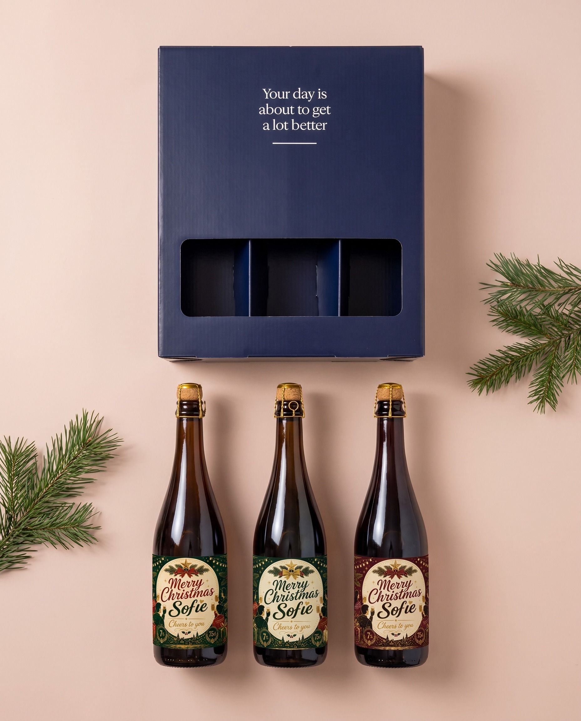 Bierpakket als kerstcadeau, drie flessen met een gepersonaliseerd kerstetiket naast de geschenkdoos