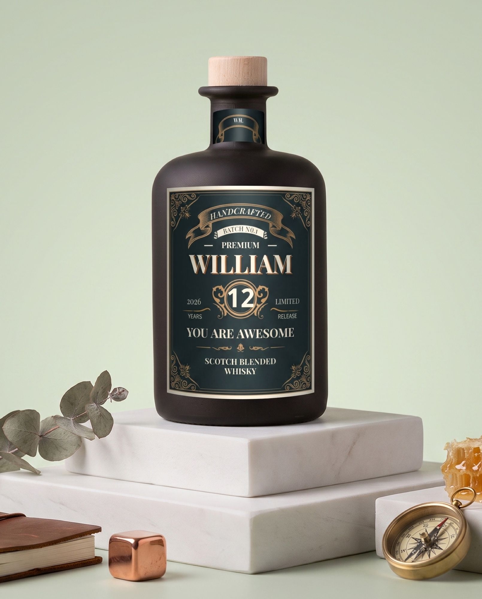 Gepersonaliseerde whisky met naam en jaartal op een goudkleurig etiket, met kompas en whiskyglas