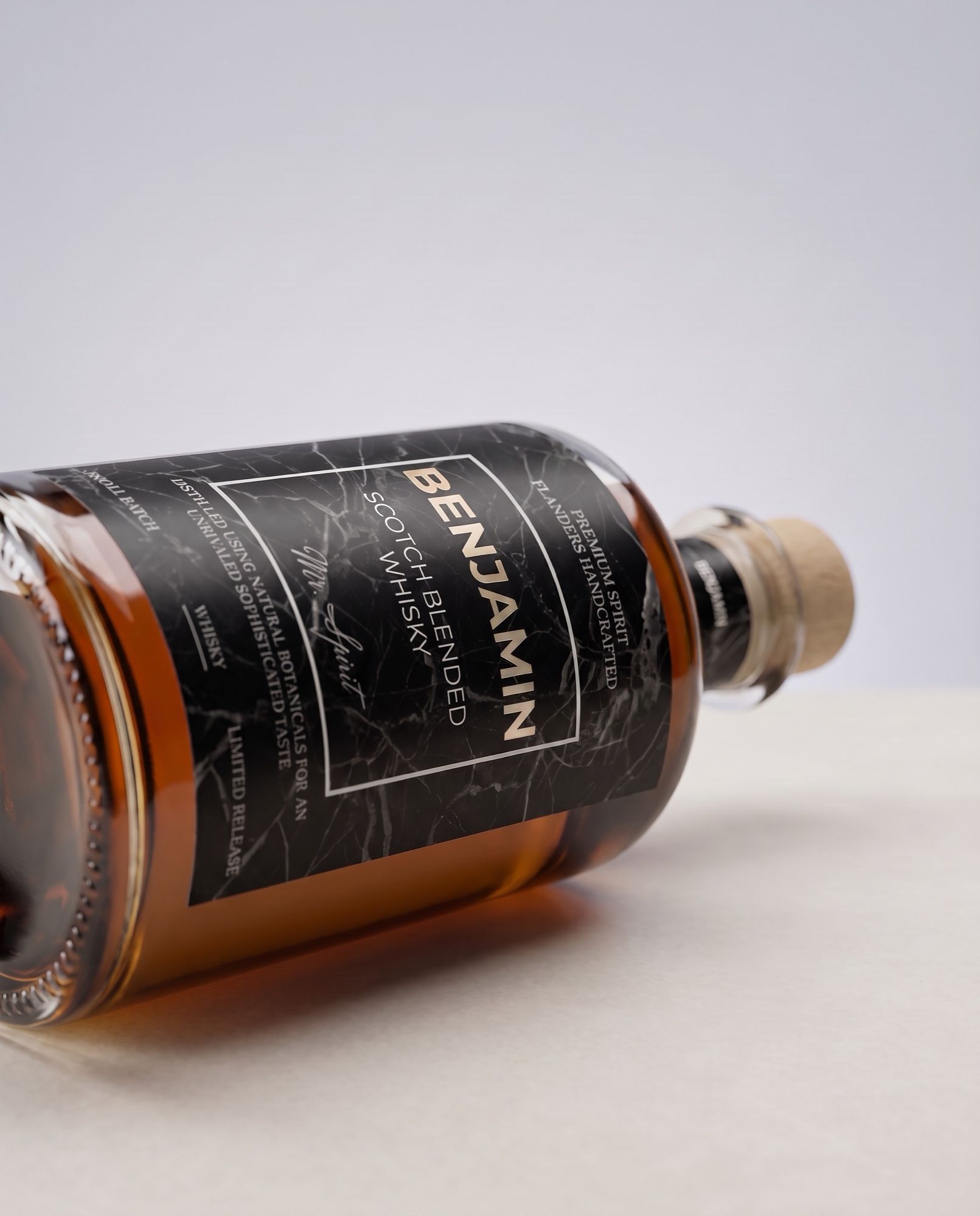Gepersonaliseerde whisky liggend op zijn zij, met het etiket met eigen naam groot in beeld