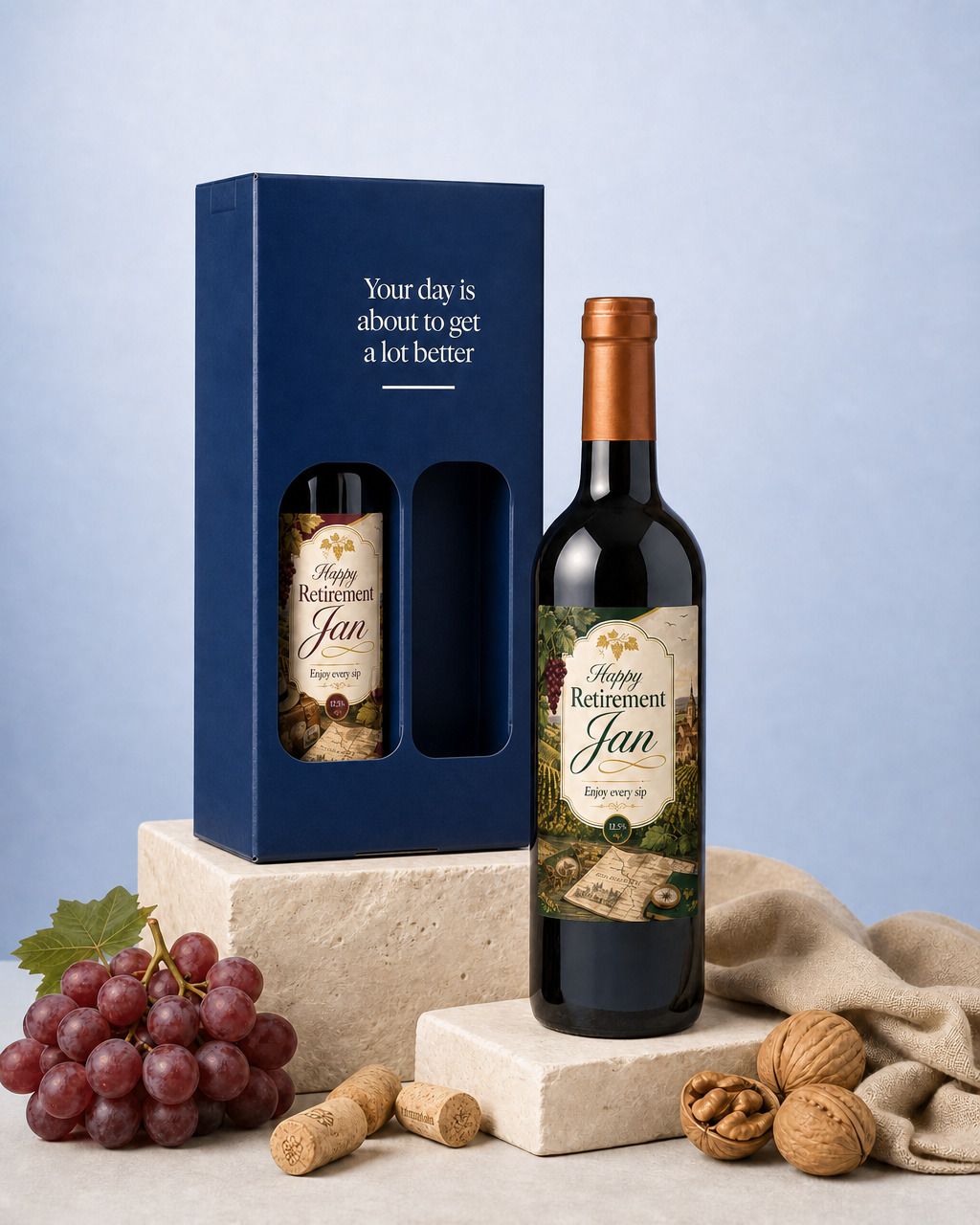 Wijnpakket met twee flessen met een gepersonaliseerd etiket als pensioencadeau, naast de donkerblauwe geschenkdoos